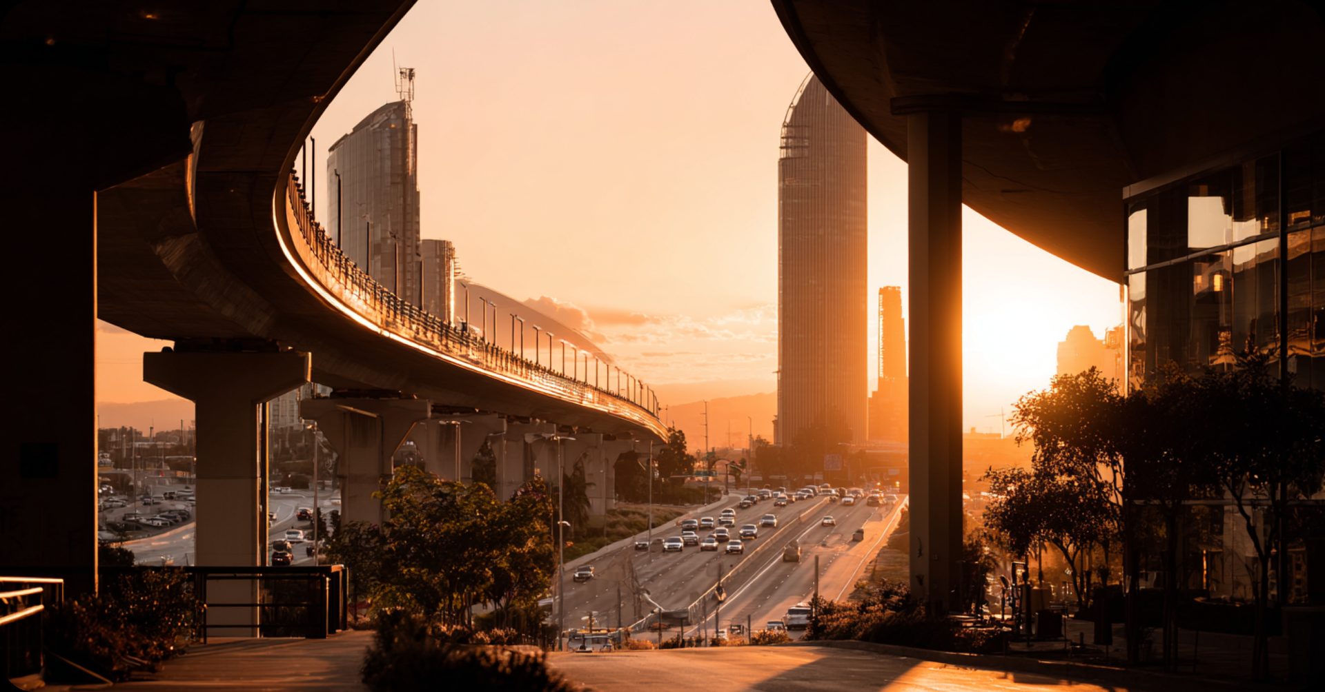 Elevated highway bridge at sunset over a city skyline, illustrating bridge financing in commercial real estate